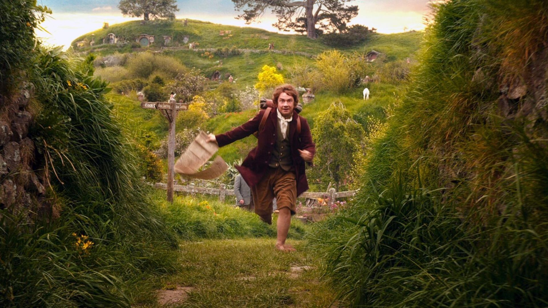 Movie poster for The Hobbit featuring a man running through a lush green field, evoking adventure and exploration.