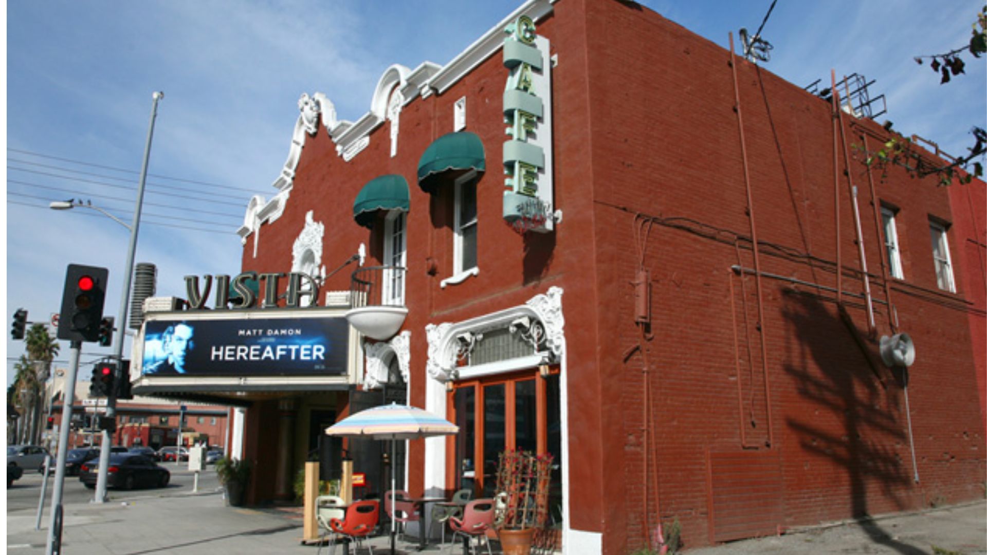A red brick building featuring a sign that reads "the theater" prominently displayed above the entrance.