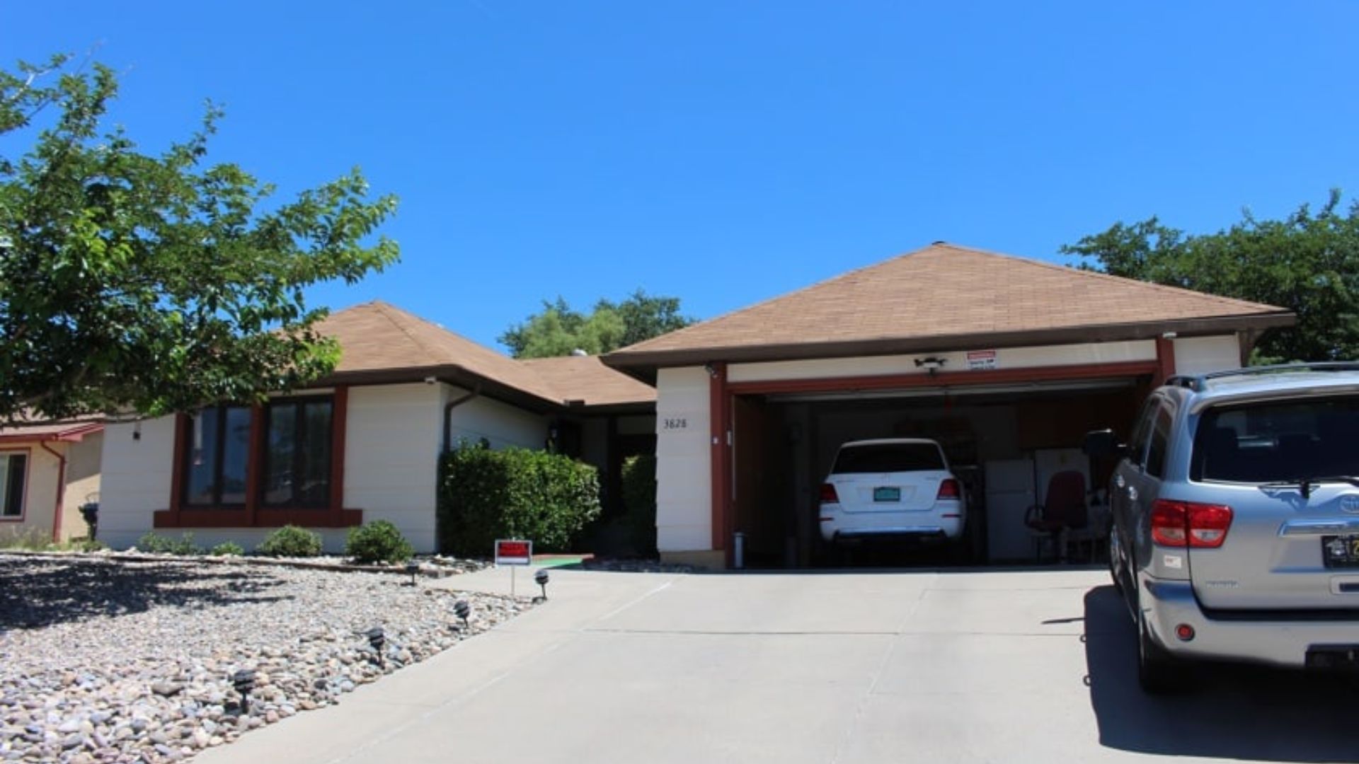 A house with a car parked in front, showcasing a suburban residential setting.