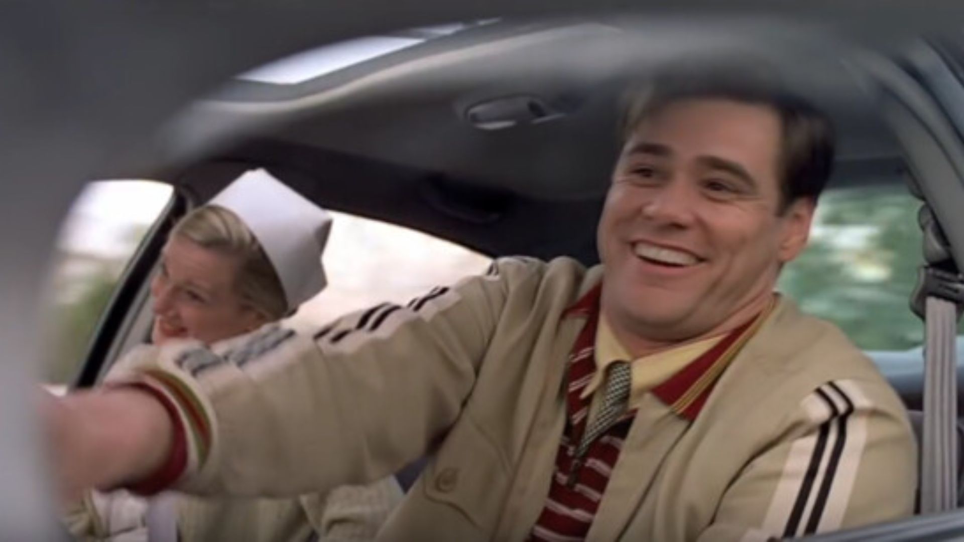 A smiling man in a car holds a nurse's hand, conveying warmth and gratitude in a moment of connection.
