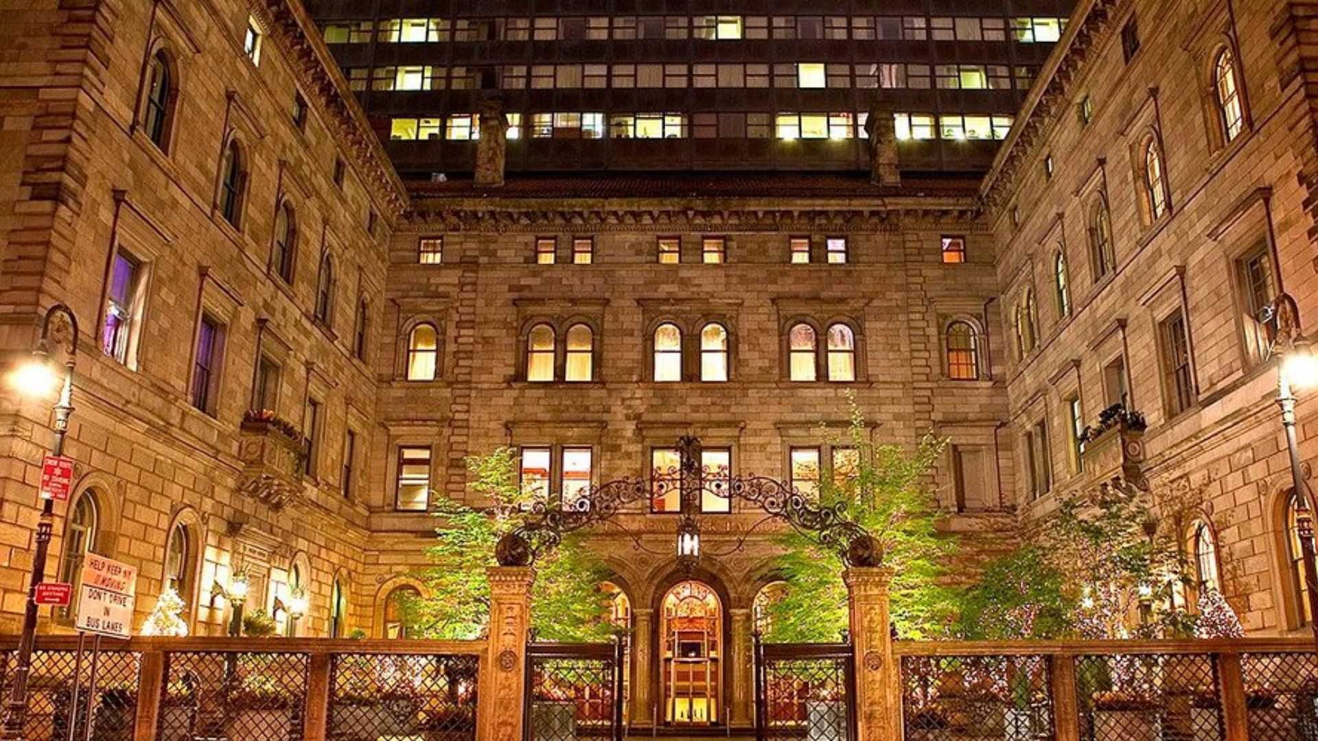 Nighttime courtyard scene with a building illuminated in the background, creating a serene and tranquil atmosphere.