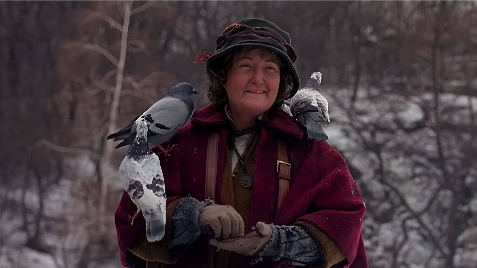 A woman in a red coat gently holds two pigeons in her hands, smiling as she interacts with the birds.