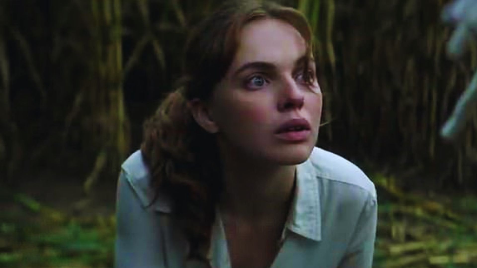 Odessa Young as Frannie Goldsmith gazes upward, wearing a white shirt, in a scene from the 2020 film "The Stand."