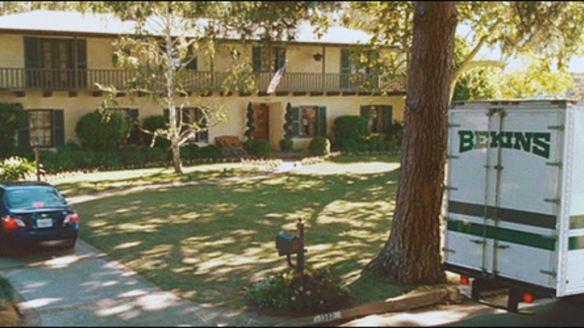  A moving truck parked in front of a house, ready for loading or unloading belongings.