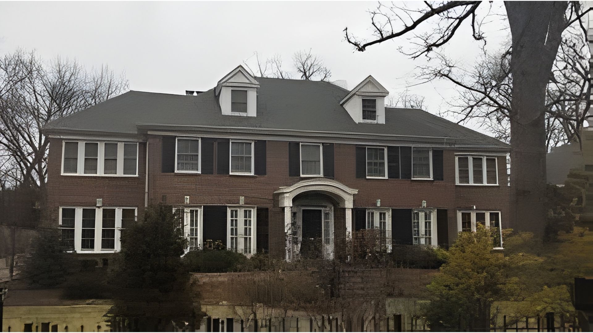 A large brick house surrounded by a spacious front yard, showcasing a well-maintained landscape.