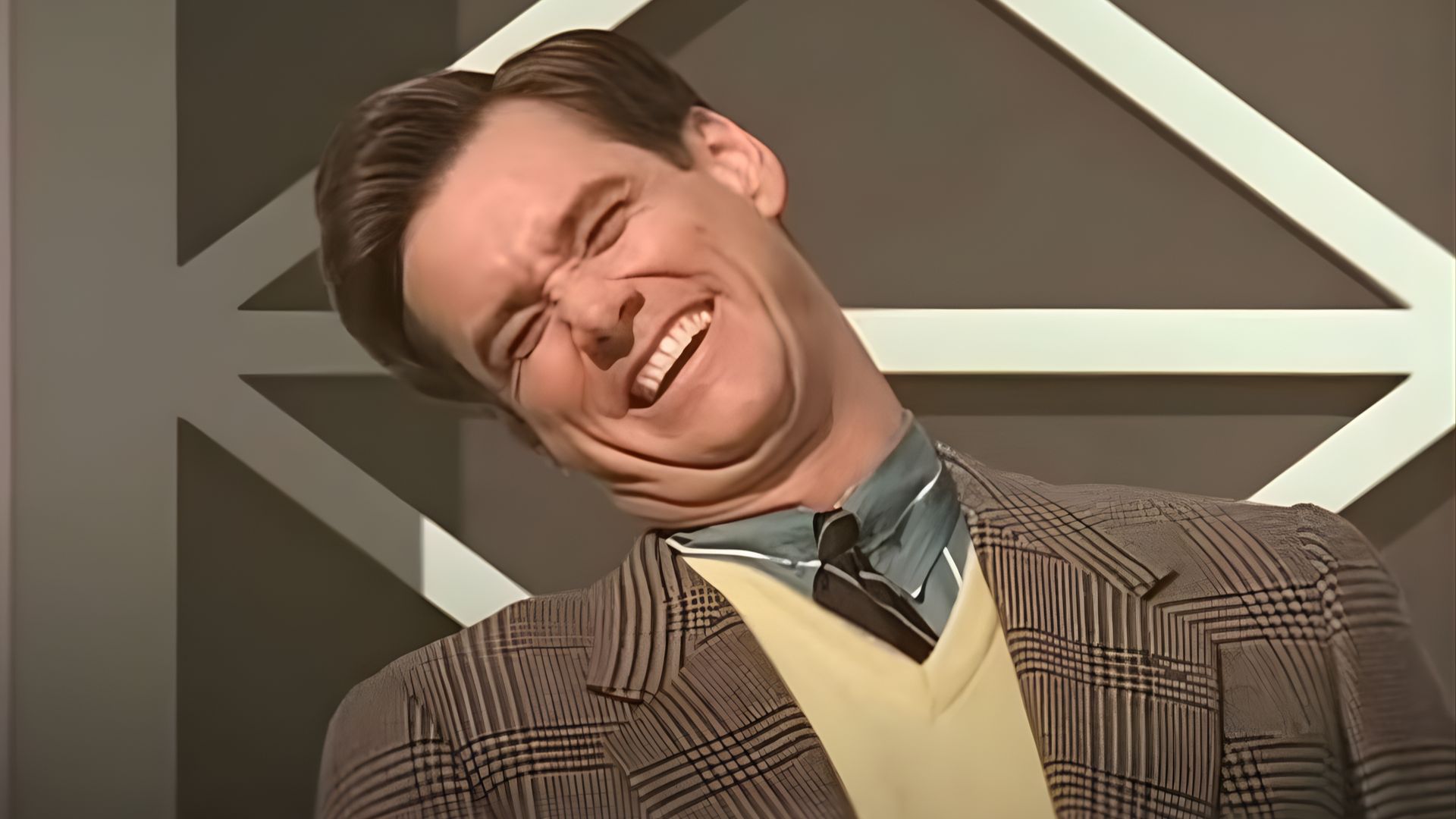 A man in a suit and tie smiles warmly at the camera.