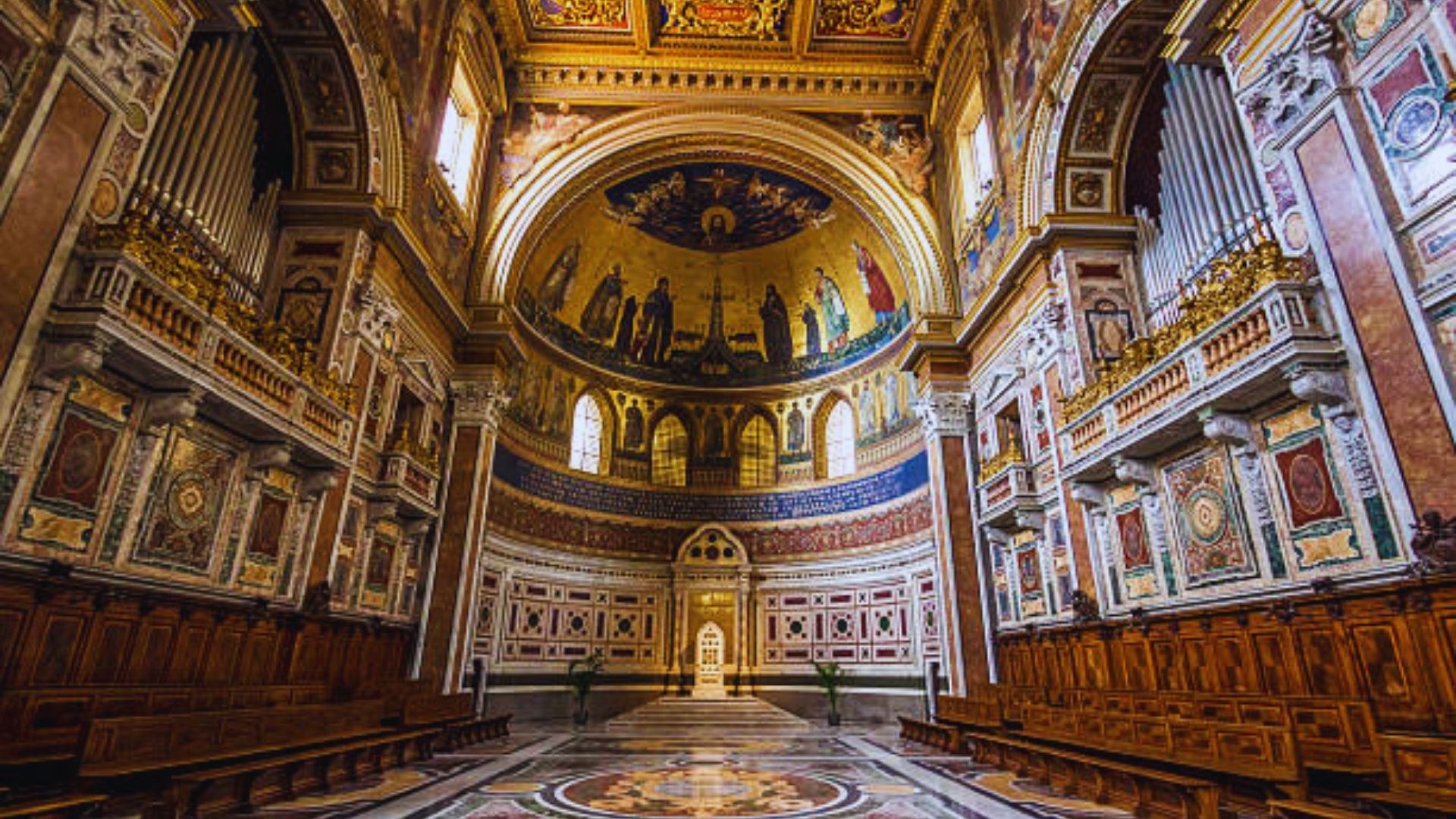 Interior view of a church showcasing a grand, vaulted ceiling and ornate architectural details.