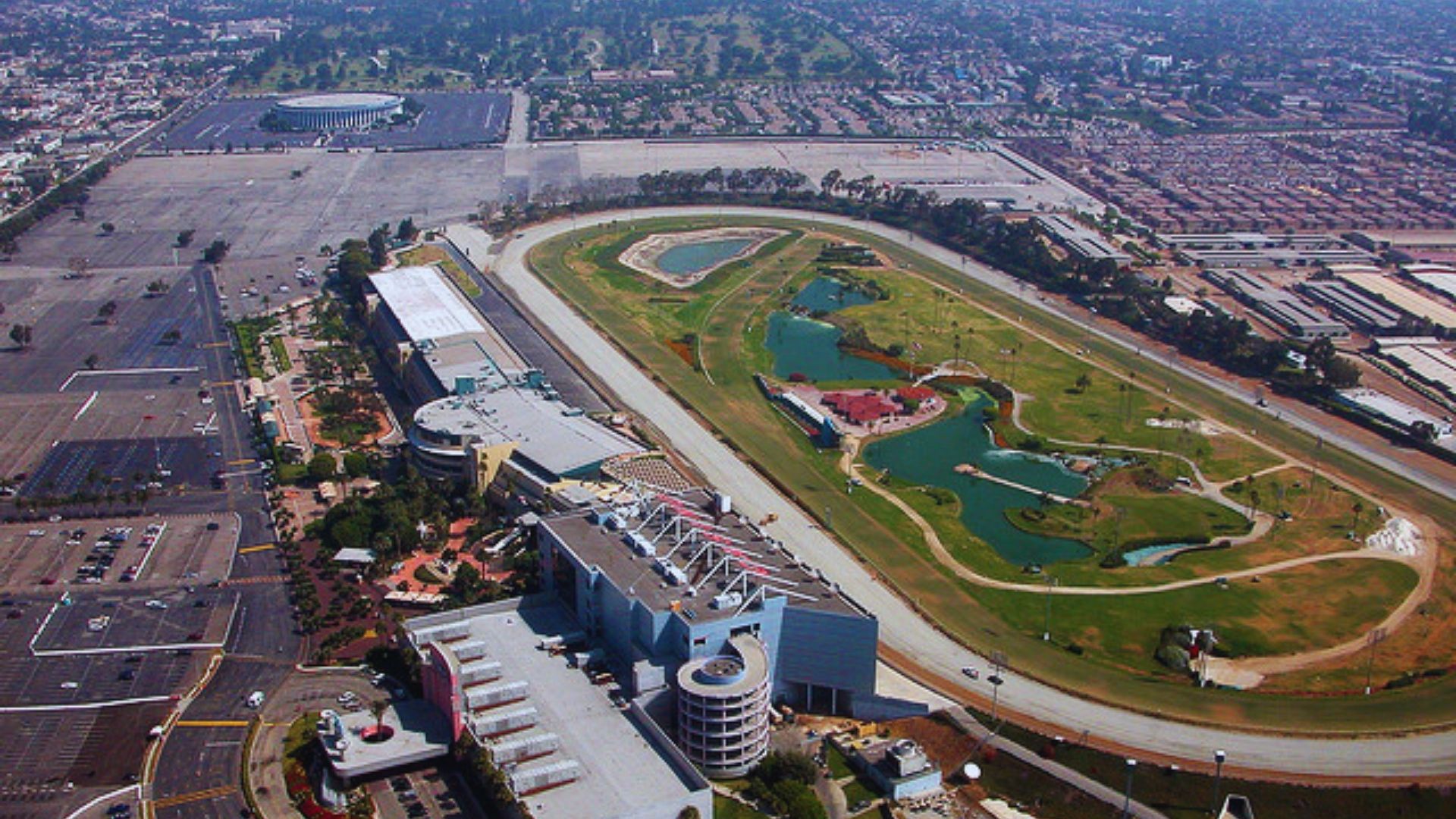 Aerial view showcasing a racetrack surrounded by a bustling cityscape below.