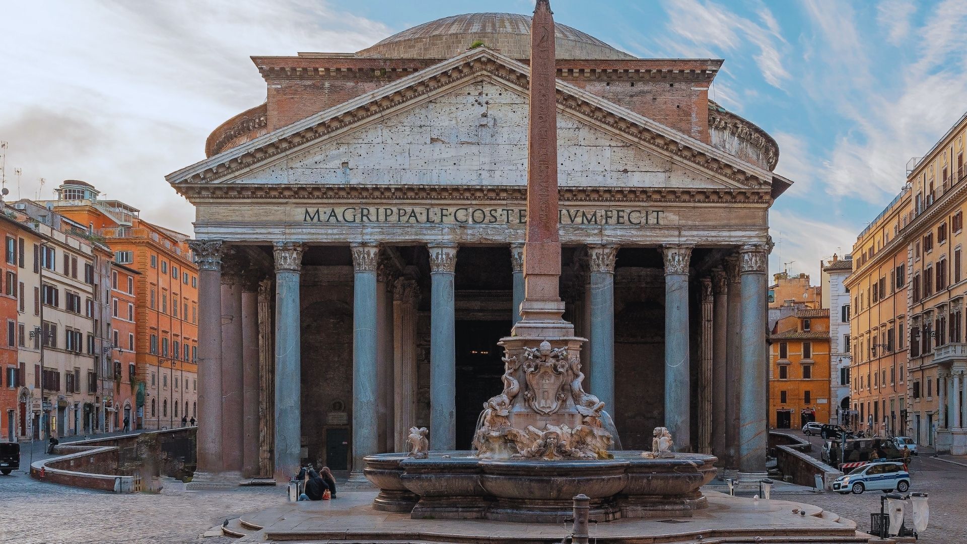 The Pantheon in Rome, Italy, showcasing its iconic dome and portico with Corinthian columns against a clear blue sky.