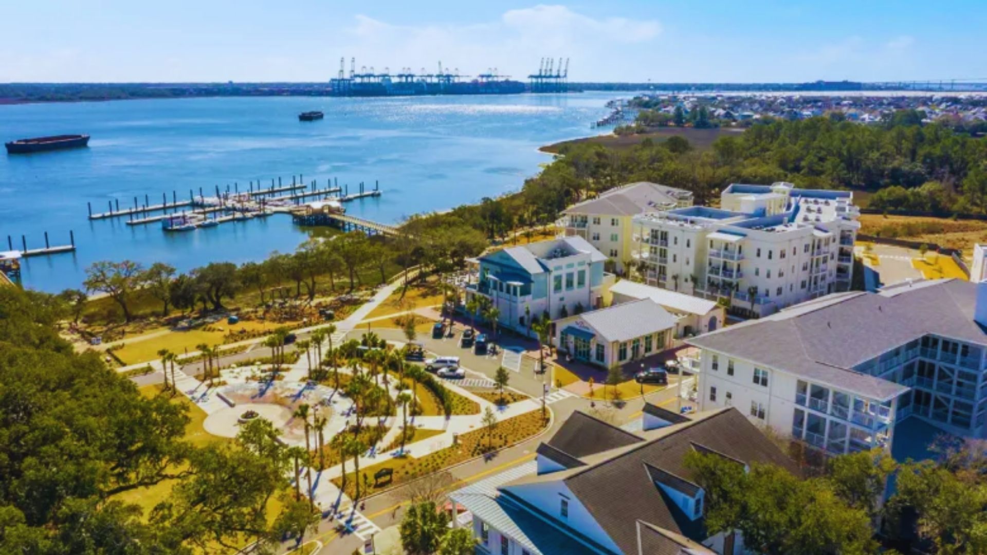 Aerial view of Charleston, SC waterfront showcasing boats, historic buildings, and lush greenery along the coastline
