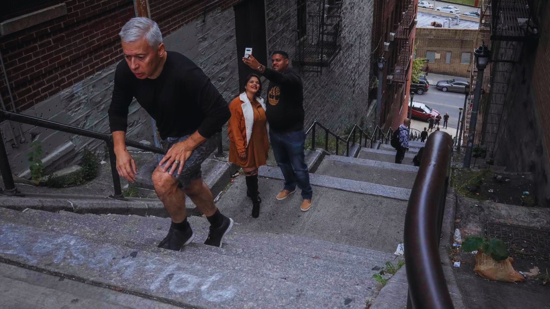Two individuals descend a staircase adorned with colorful graffiti, showcasing urban art and street culture.
