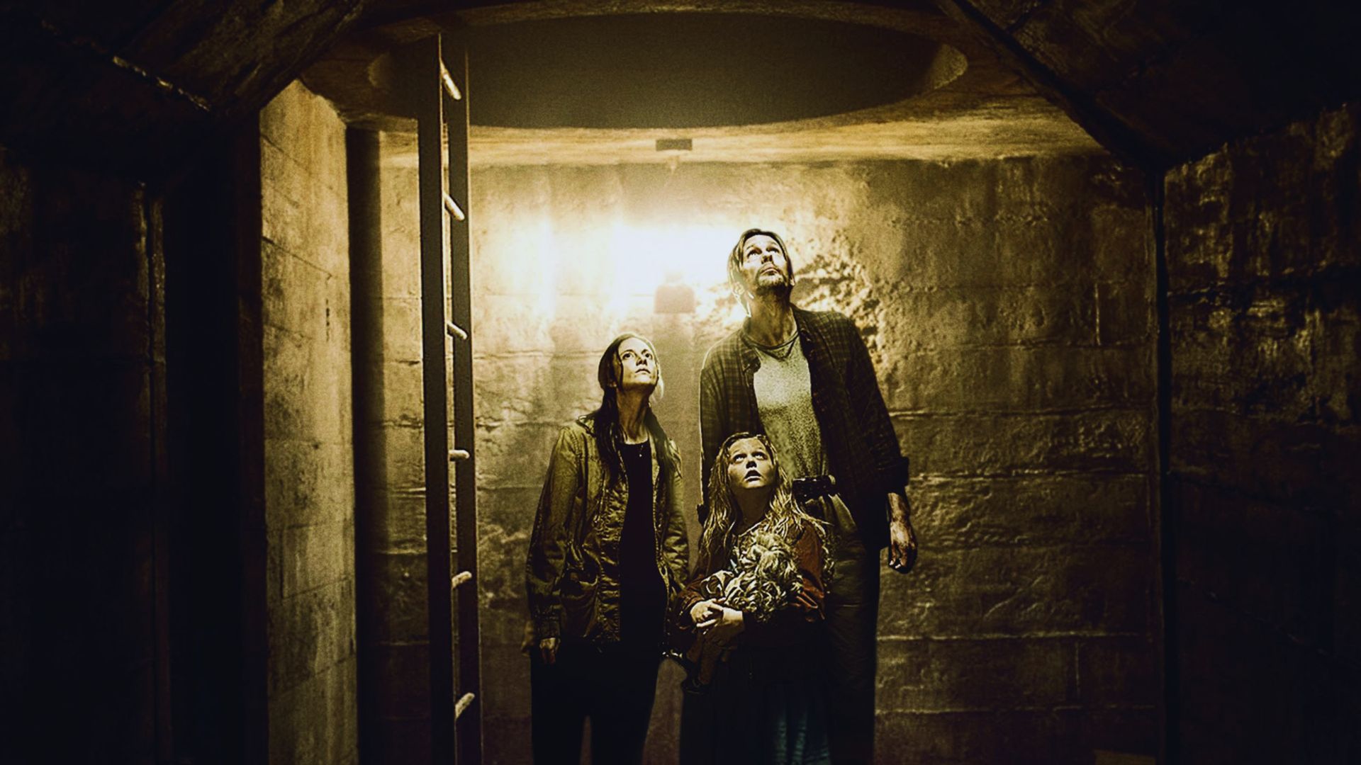 A man and woman stand together in a dimly lit tunnel, surrounded by dark walls and shadows.