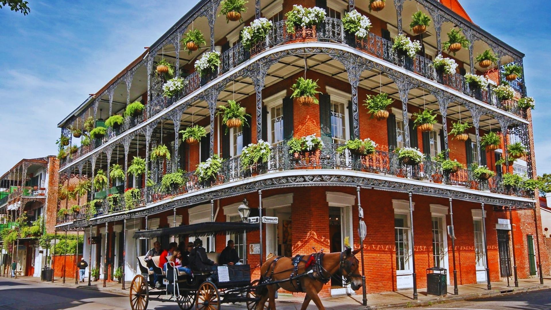 A horse-drawn carriage is parked in front of a historic building, showcasing a charming scene of transportation.