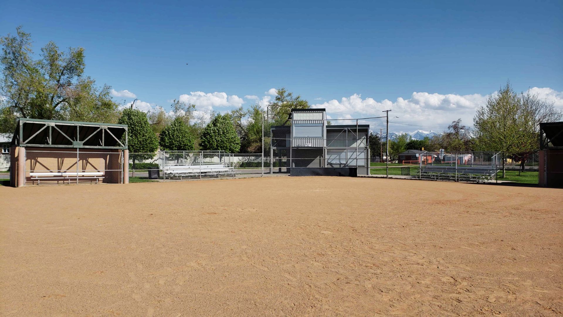 A baseball diamond on a field, enclosed by a fence, showcasing a location from The Sandlot film.
