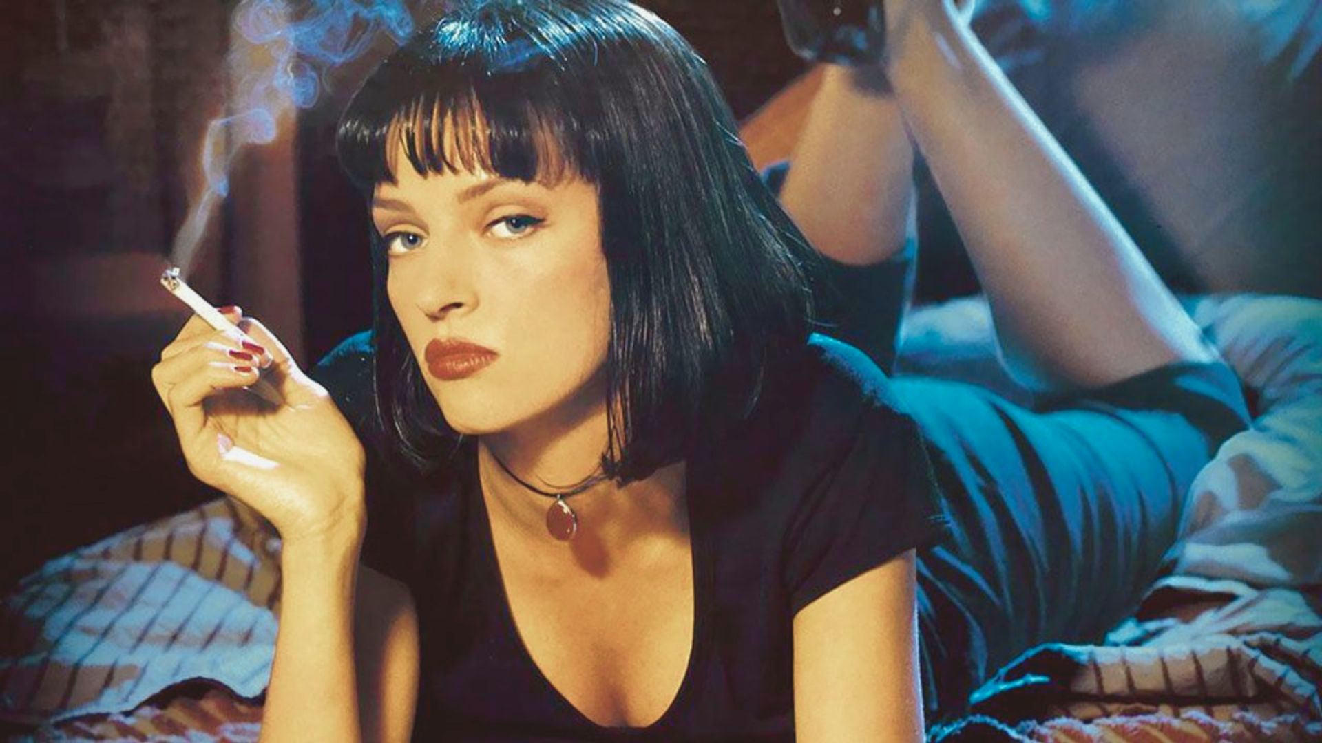 Woman with a black bob haircut lying on a bed, holding a cigarette. She wears a black dress and looks thoughtfully at the camera, exuding a mysterious vibe.