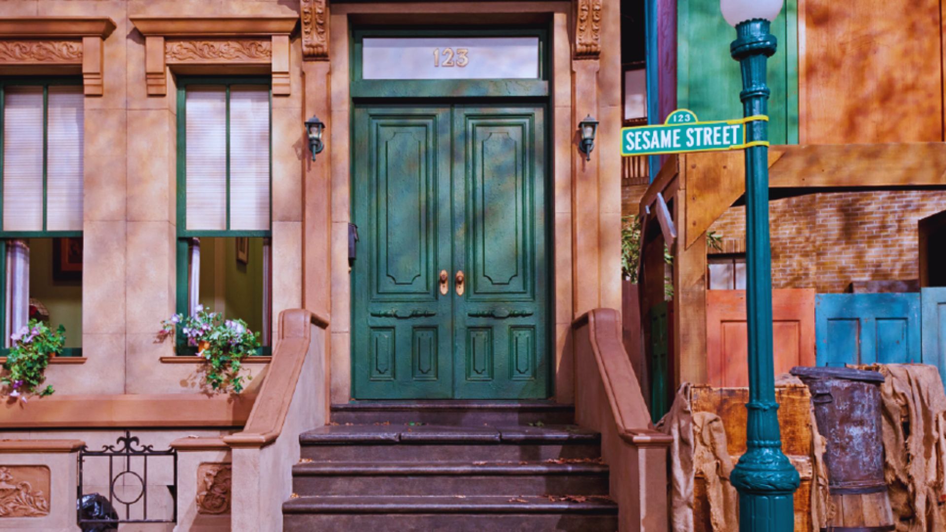 Iconic Sesame Street set with the 123 building entrance, green doors, and street sign in a colorful urban neighborhood.