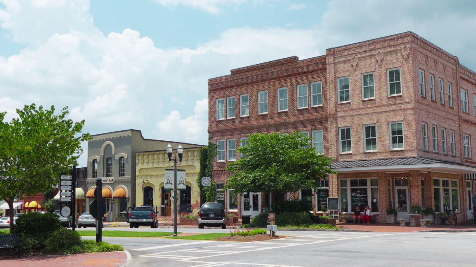 A city street featuring several buildings and a parked car, noted as a filming location for The Walking Dead.
