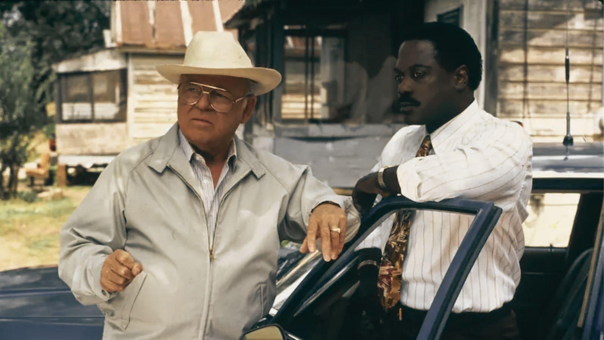 Carroll O'Connor as Chief Gillespie and Howard Rollins as Virgil Tibbs stand by a car.