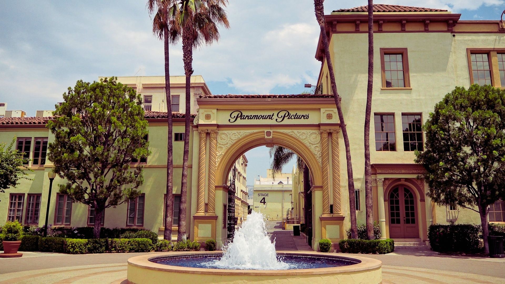 The ornate Paramount Pictures arch entrance with a fountain in front and Stage 4 visible beyond.
