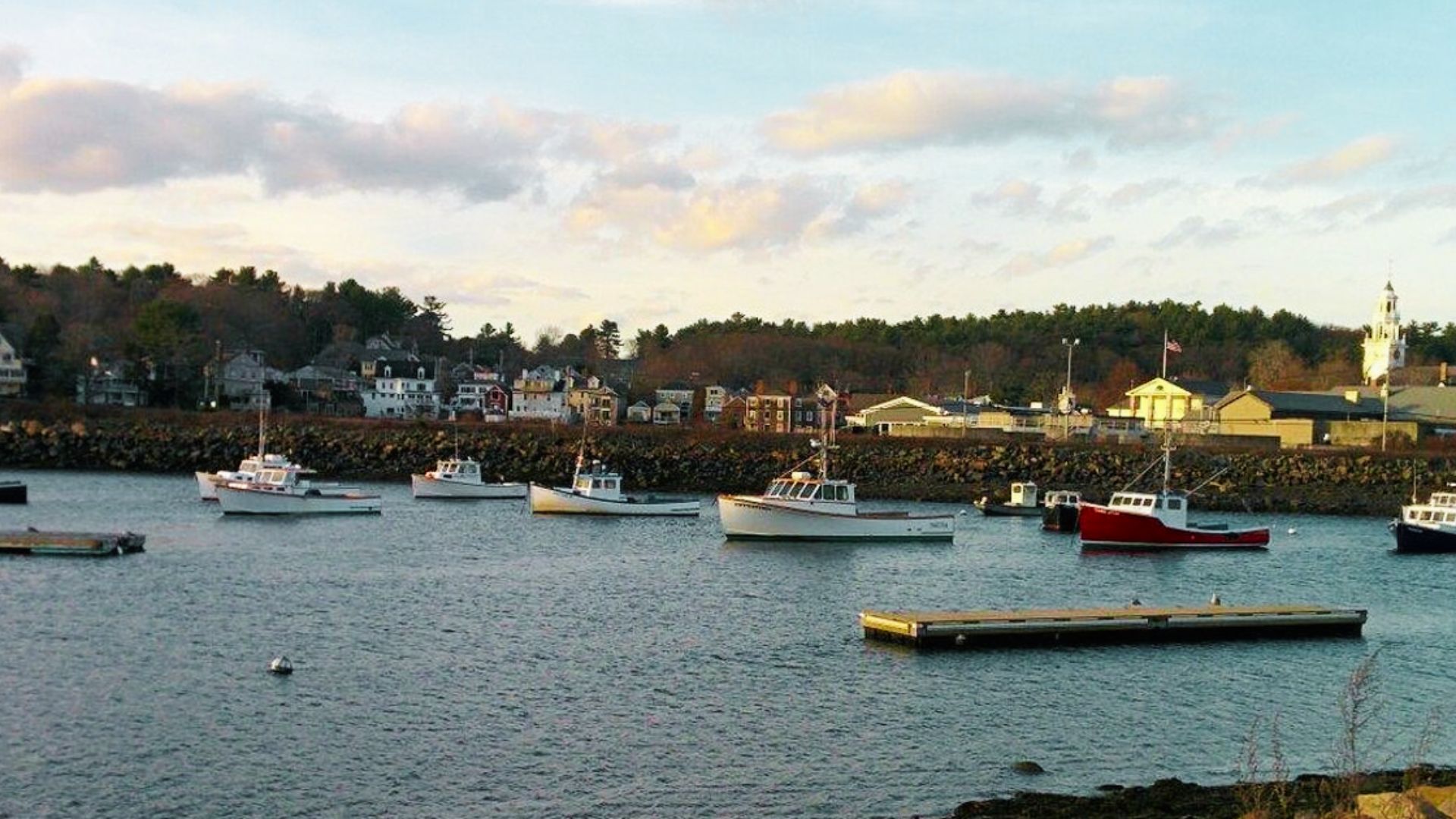 Lobster boats and fishing vessels anchor in Manchester-by-the-Sea’s protected harbor at dusk.