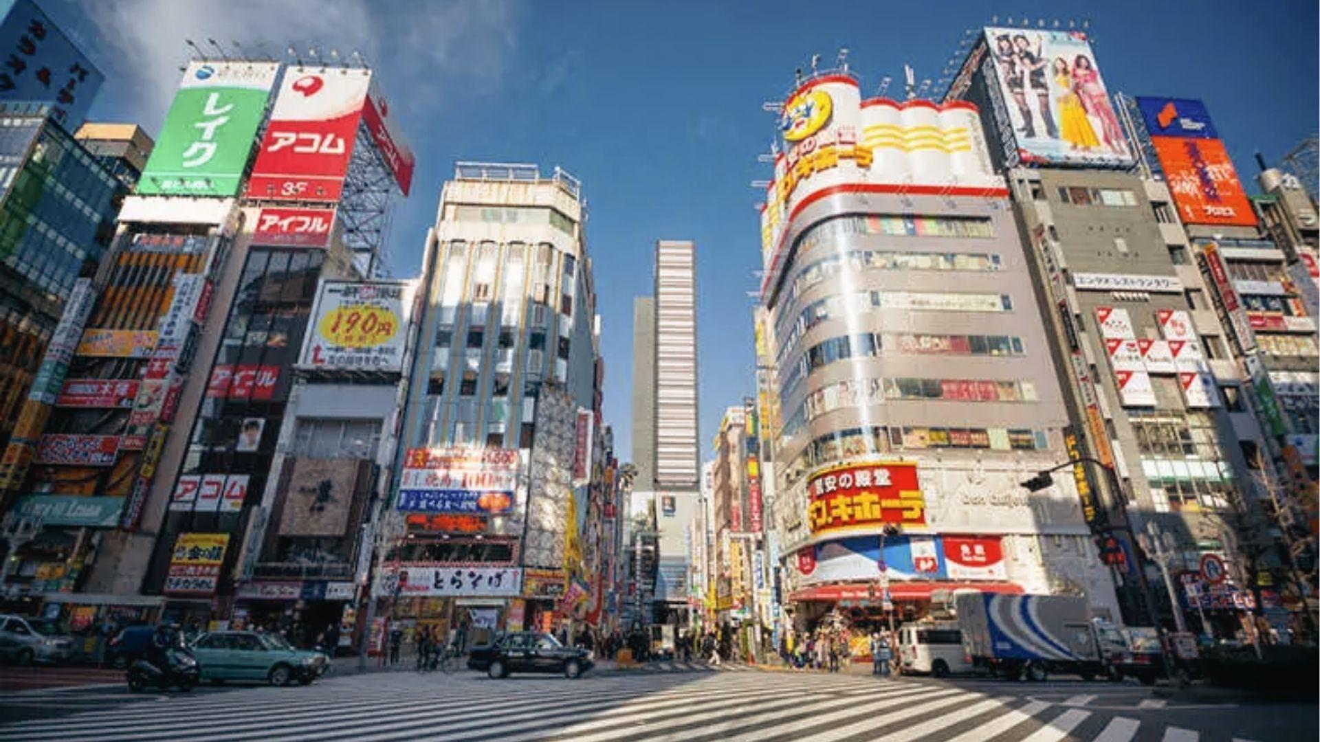 Daytime view of Shinjuku’s busy crossing surrounded by skyscrapers, Don Quijote, and colorful ads.