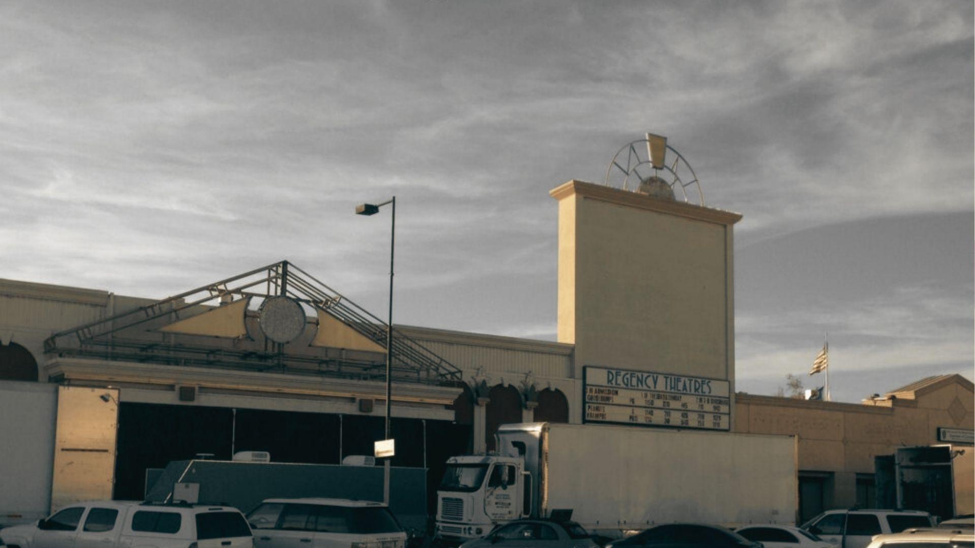 The Regency Theatres facade on a studio backlot, with production trucks parked out front.
