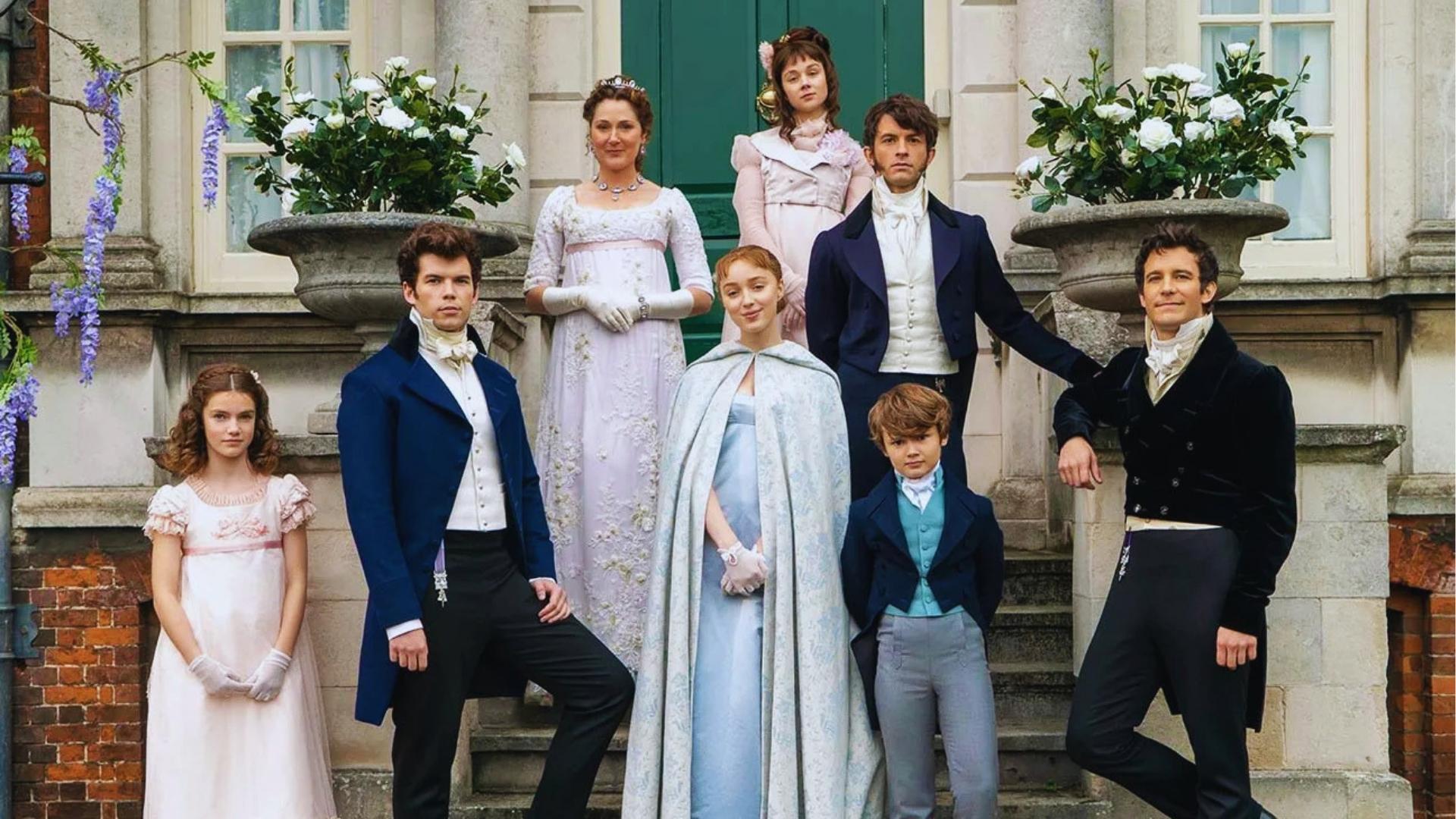 Bridgerton family posing on stone steps in Regency costumes outside their London home with wisteria and white roses.