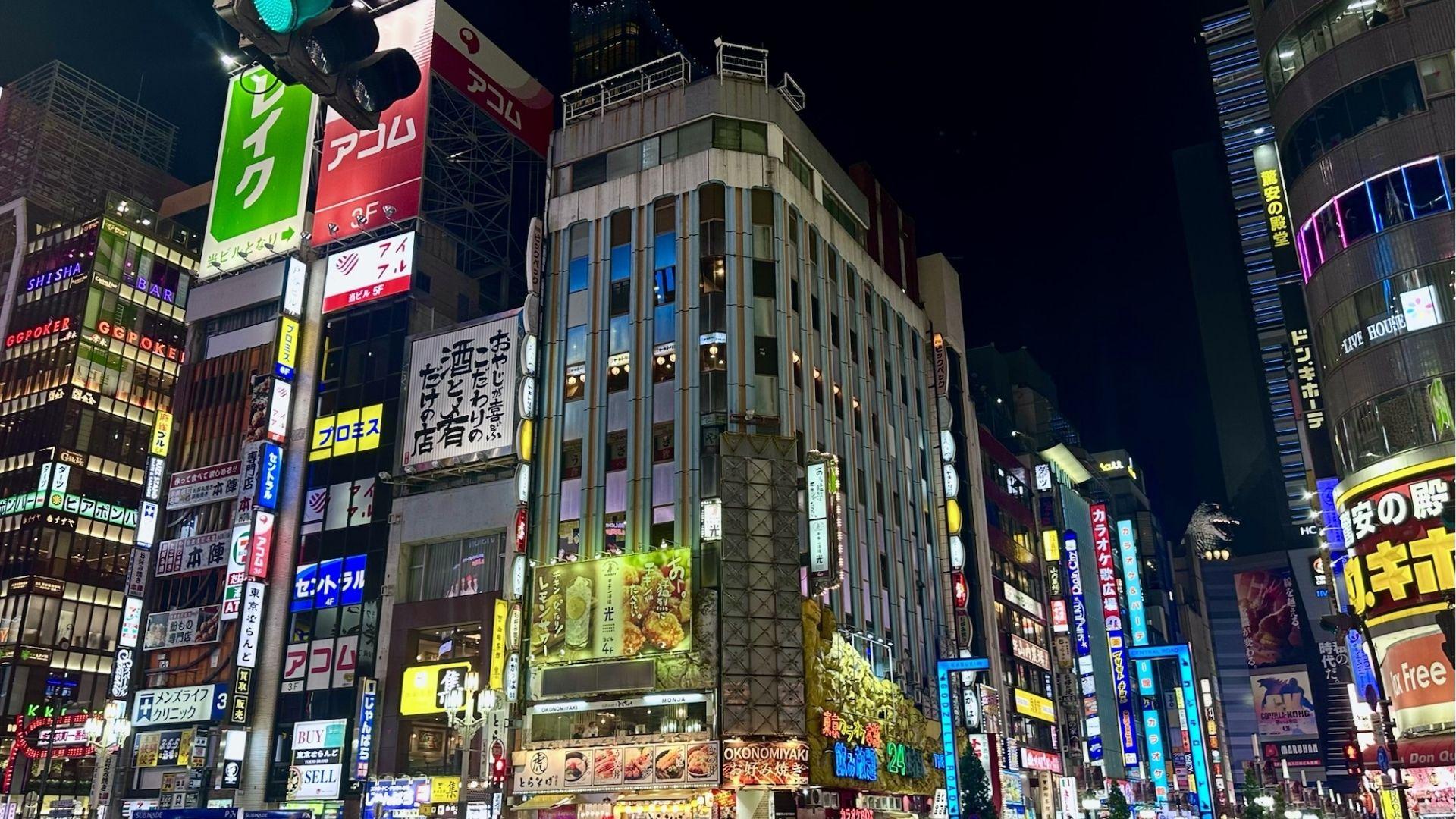 Kabukicho at night packed with neon signs, restaurants, and the Godzilla head above Toho Cinema.