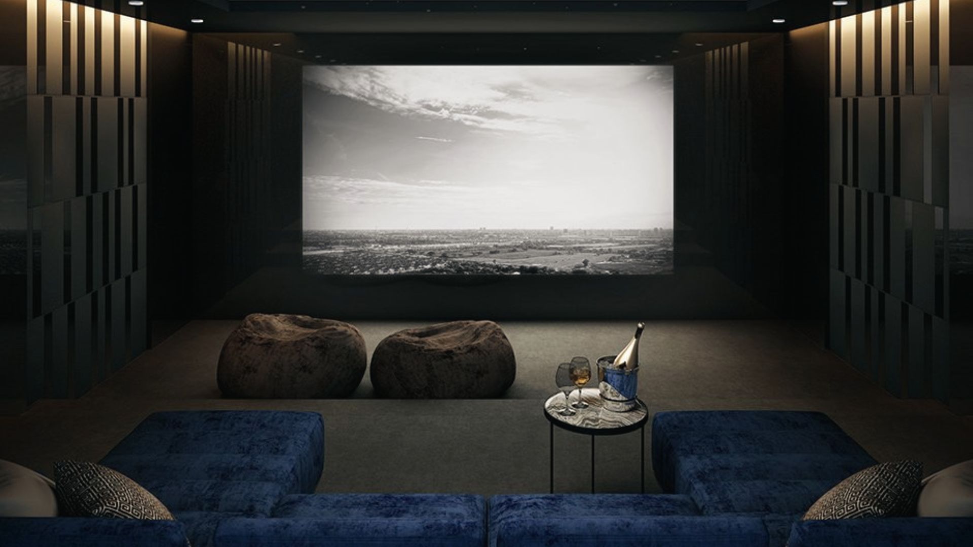 Bright, open-concept media room with large windows, plush sofas, and a massive wall-mounted screen.