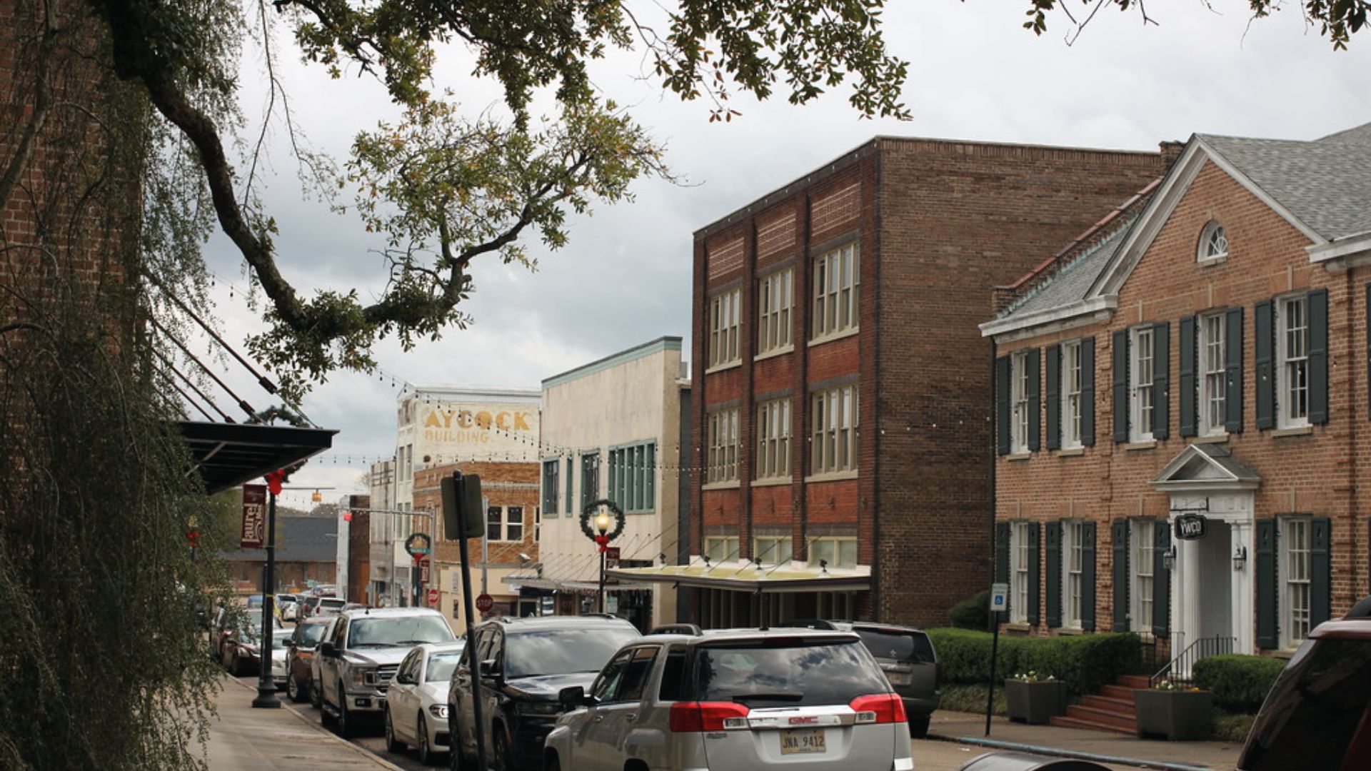 Downtown Laurel, Mississippi street view with parked cars and historic brick buildings including the Aycock Building.