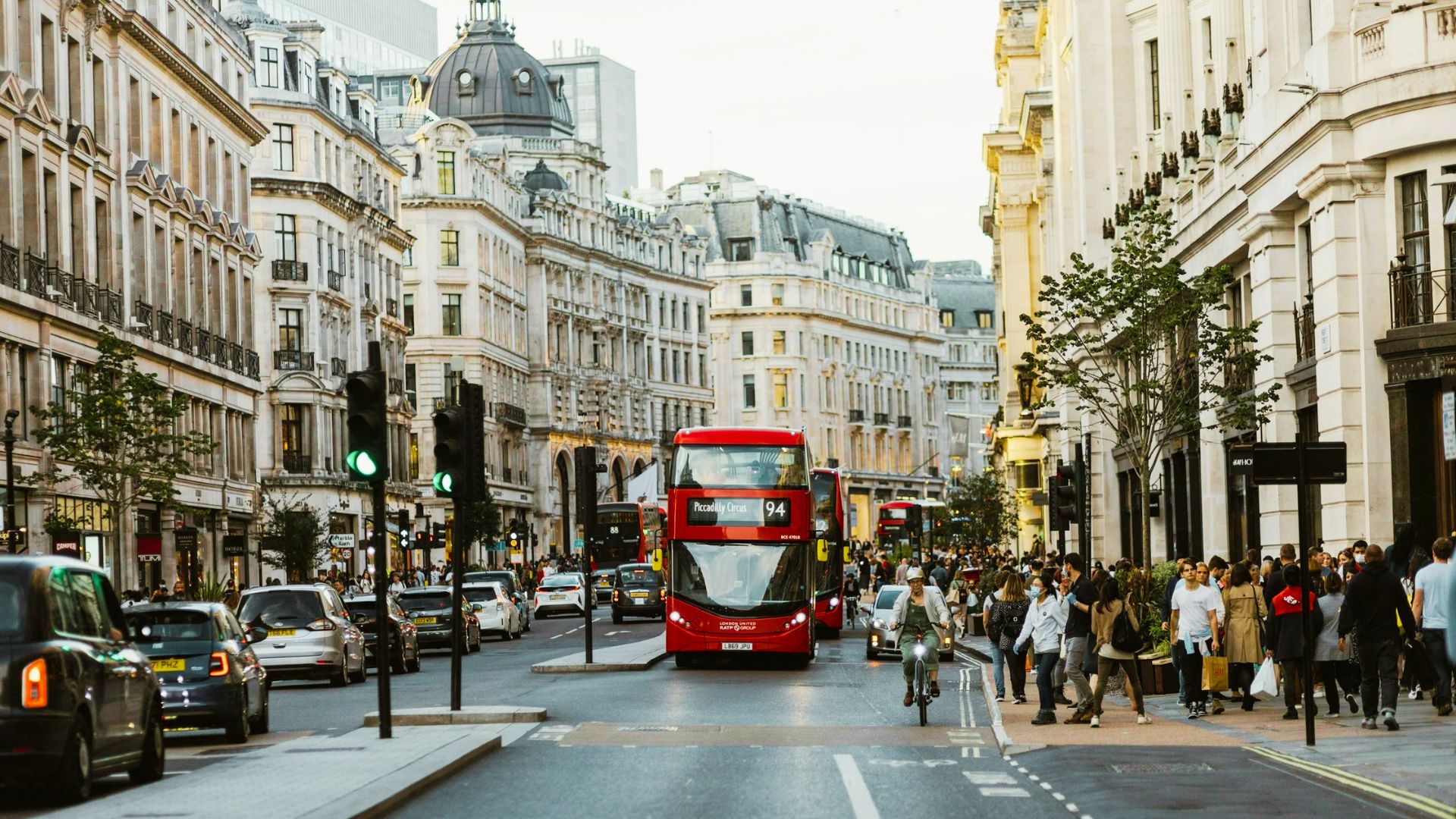 Crowded Oxford Street, London with red buses and grand buildings makes the West End a prime spot to stay for shopping, theatres, and central Tube access.