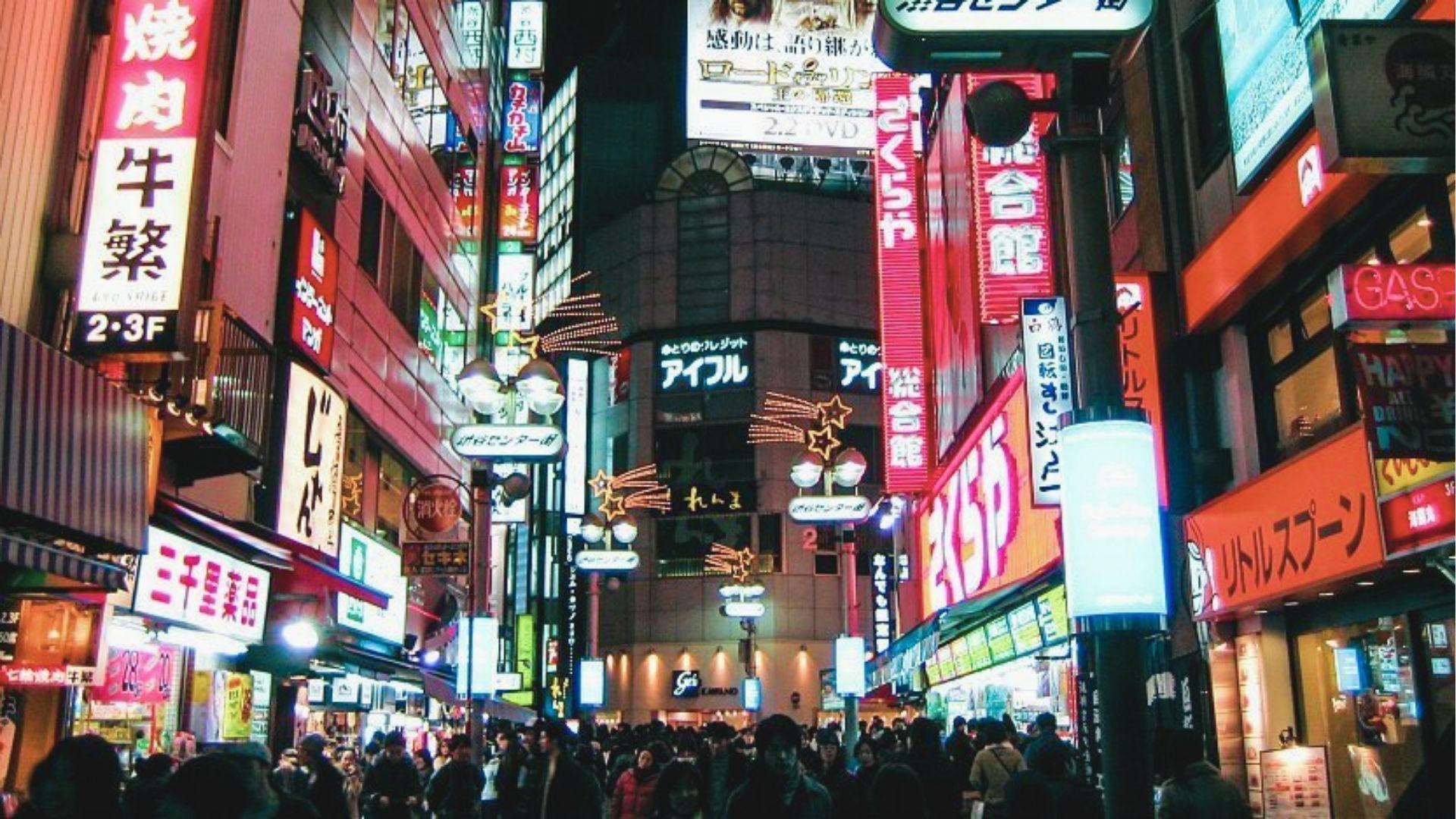 Shibuya’s narrow alley glows with neon signs for ramen shops, bars, and karaoke at night.
