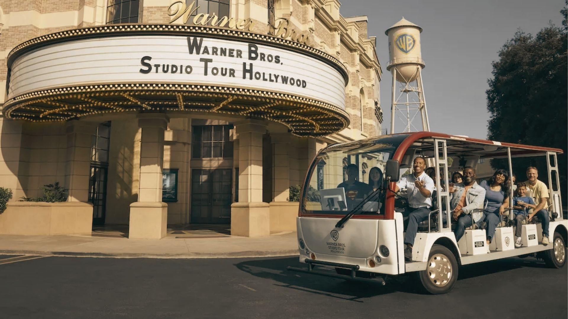 The Warner Bros. Studio Tour Hollywood entrance, with tour cart and iconic water tower in view.