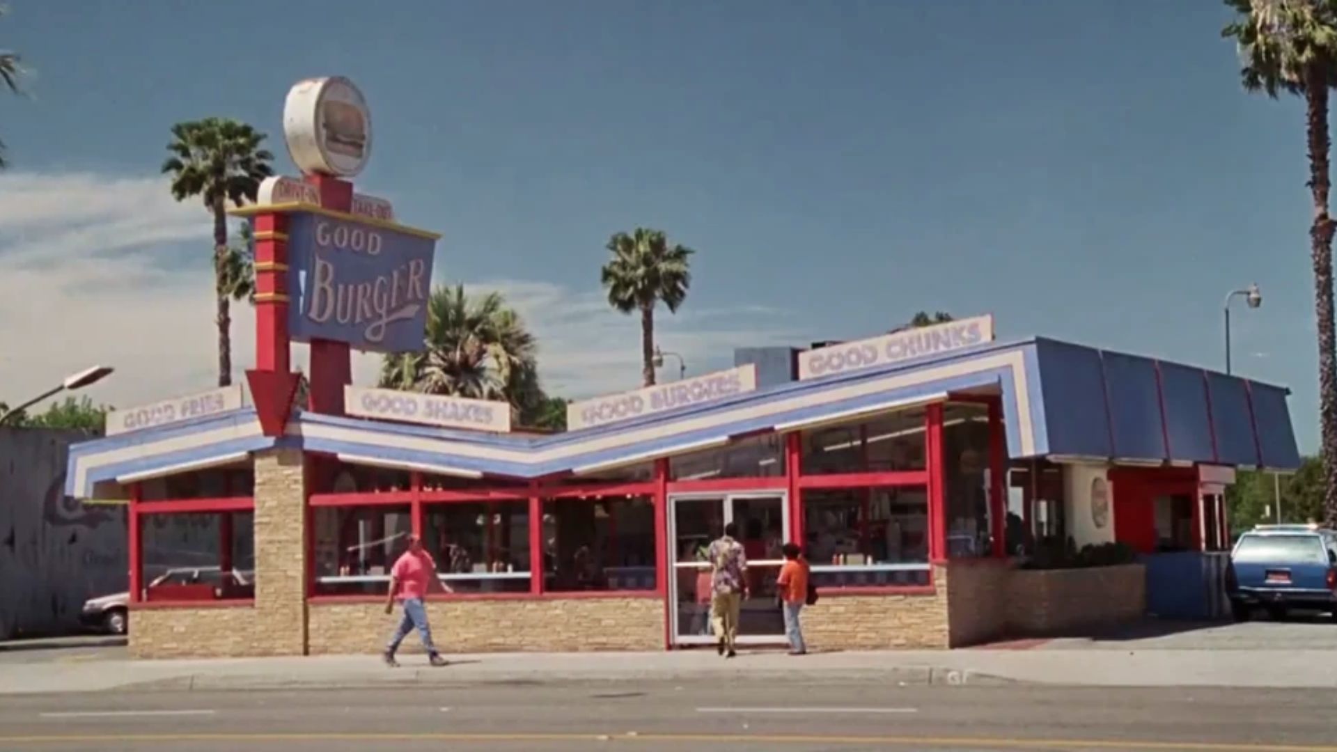 Exterior of the original Good Burger restaurant with retro signage and palm trees from the 1997 film.
