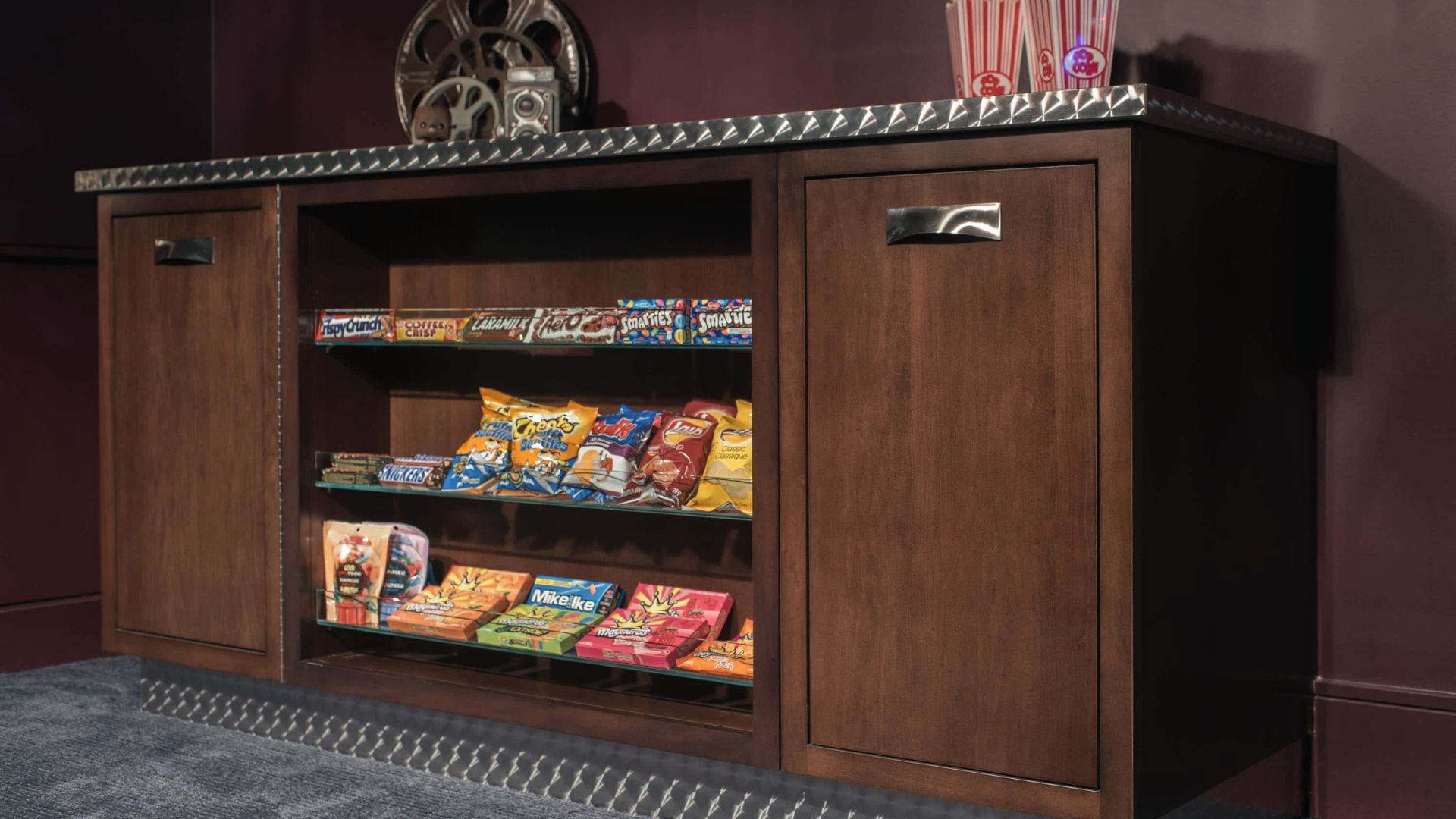 Vintage-style concession cabinet stocked with candy, chips, and chocolate bars.