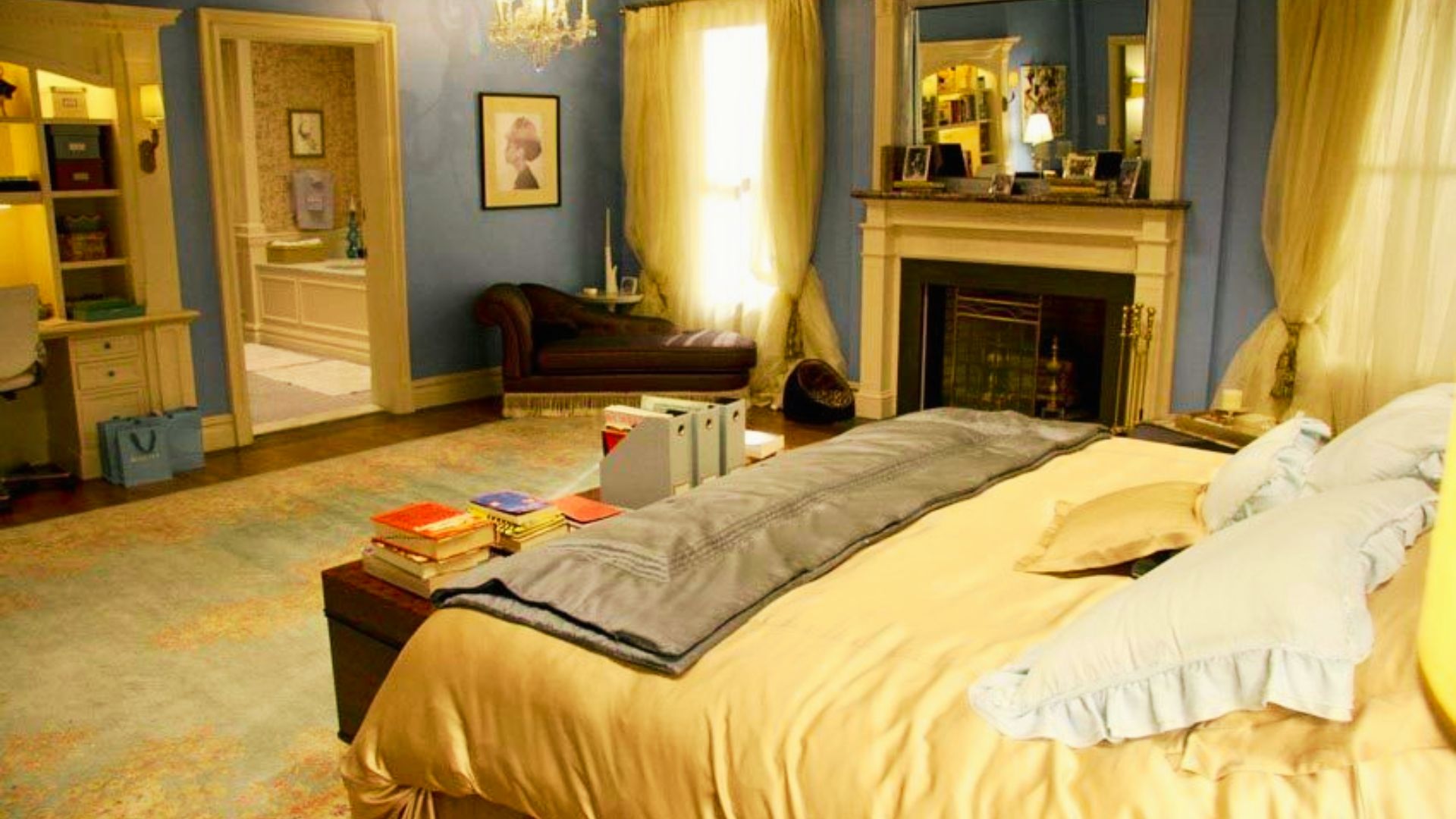 Blair Waldorf’s bedroom with powder blue walls, white fireplace, and crystal chandelier, shot from the foot of her gold silk bed.