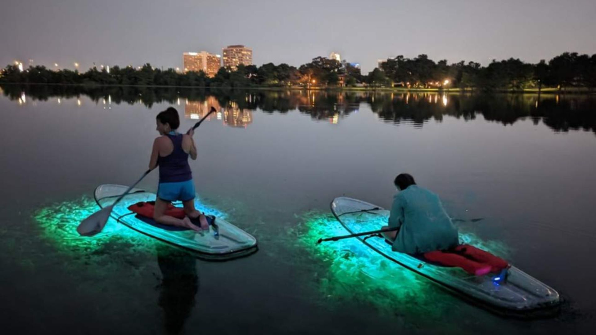 A COUPLE PADDLEBOARDING DURING NIGHT
