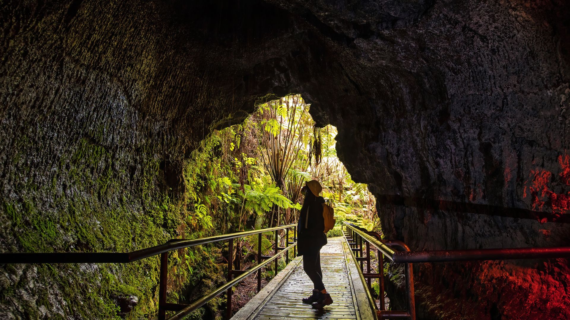 A MAN ADMIRING LAVA TUBE CAVE
