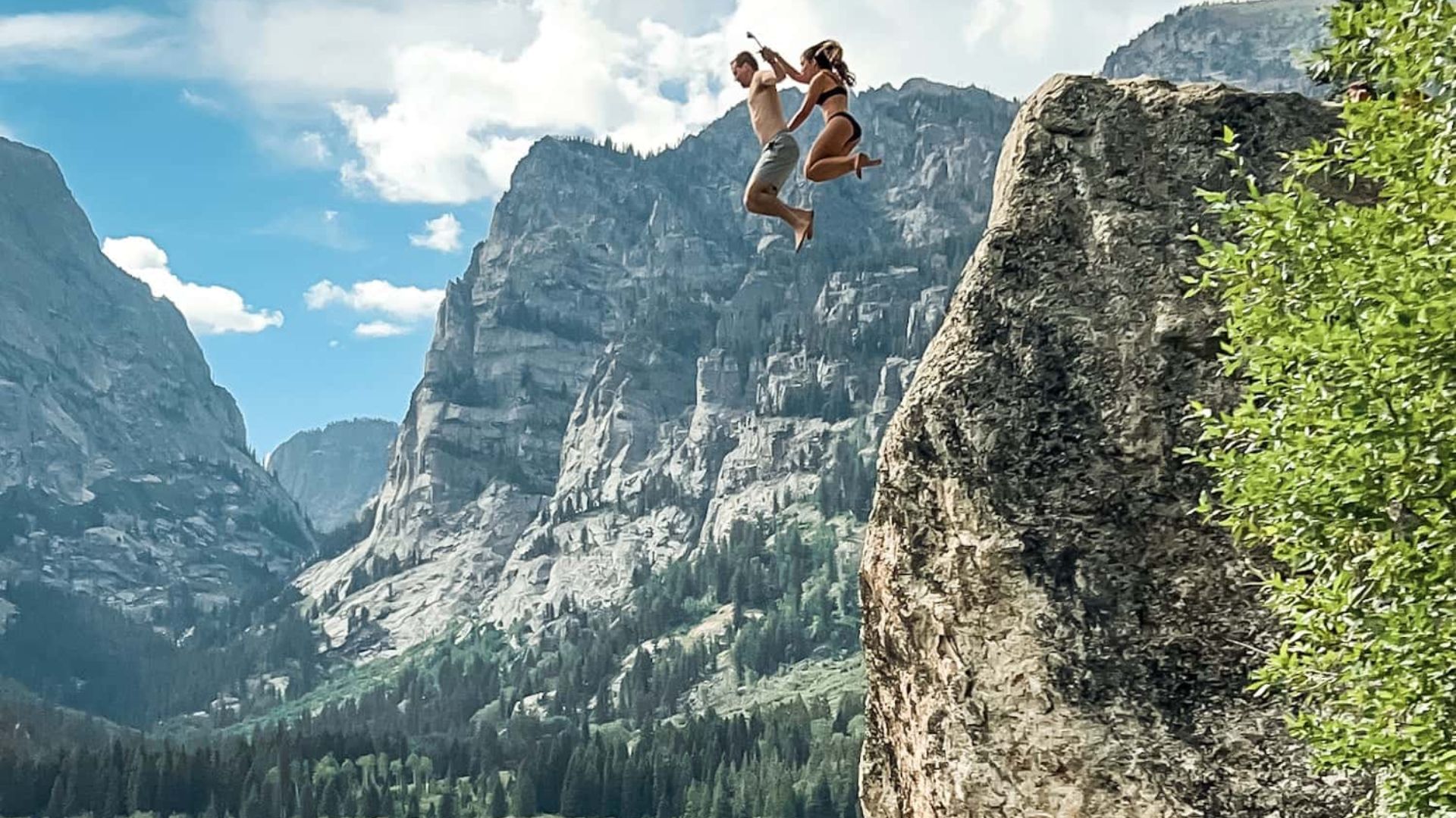 A COUPLE CLIFF JUMPING INTO ALPINE LAKES
