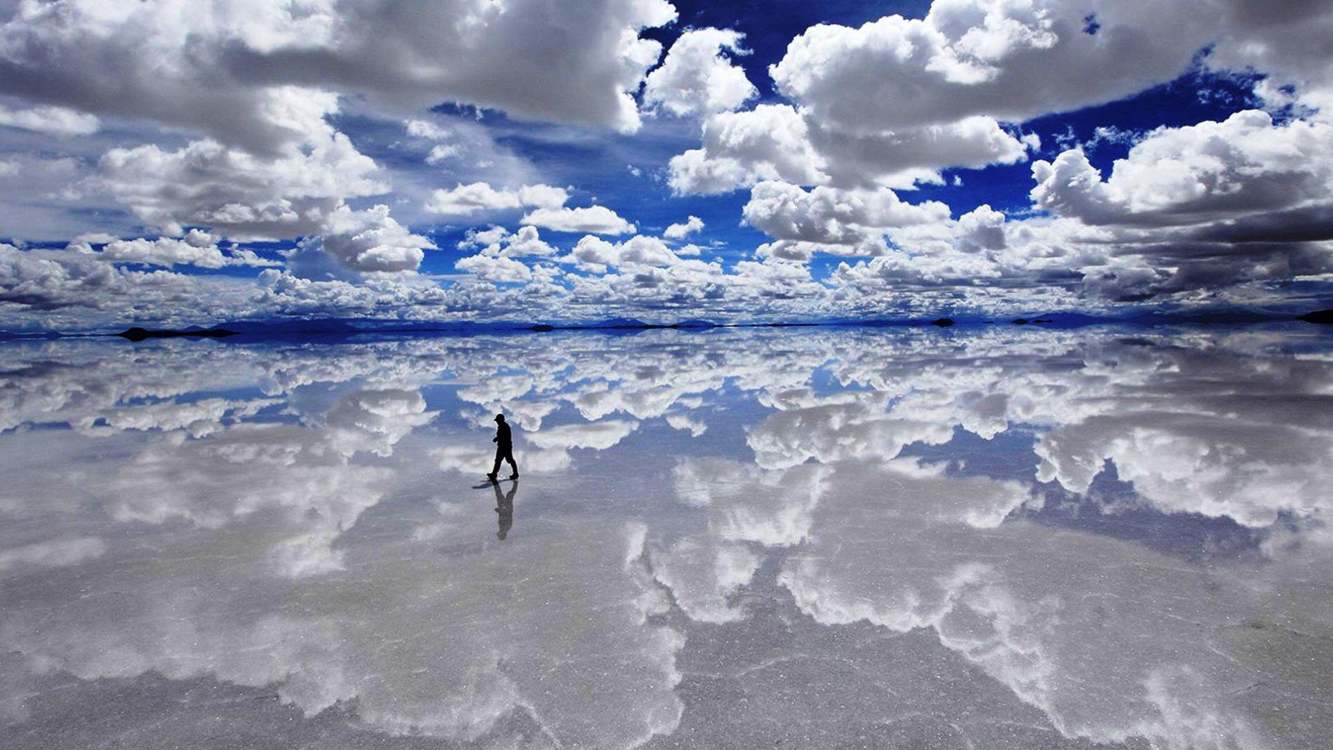 A MAN STANDING ON THE BONNEVILLE SALT FLATS, SCENEIC VIEW
