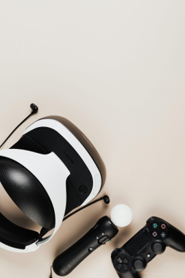 pair of virtual reality glasses alongside two game controllers on a flat surface.