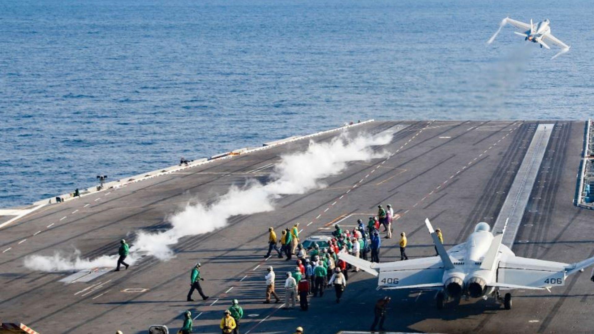Fighter jets preparing for flight on an aircraft carrier in a dramatic still from Top Gun: Maverick.