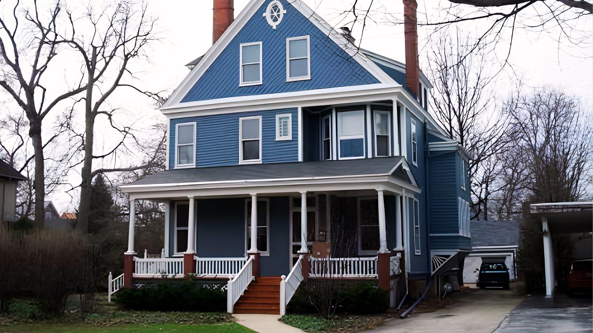 A blue house with white trim featuring a welcoming porch.