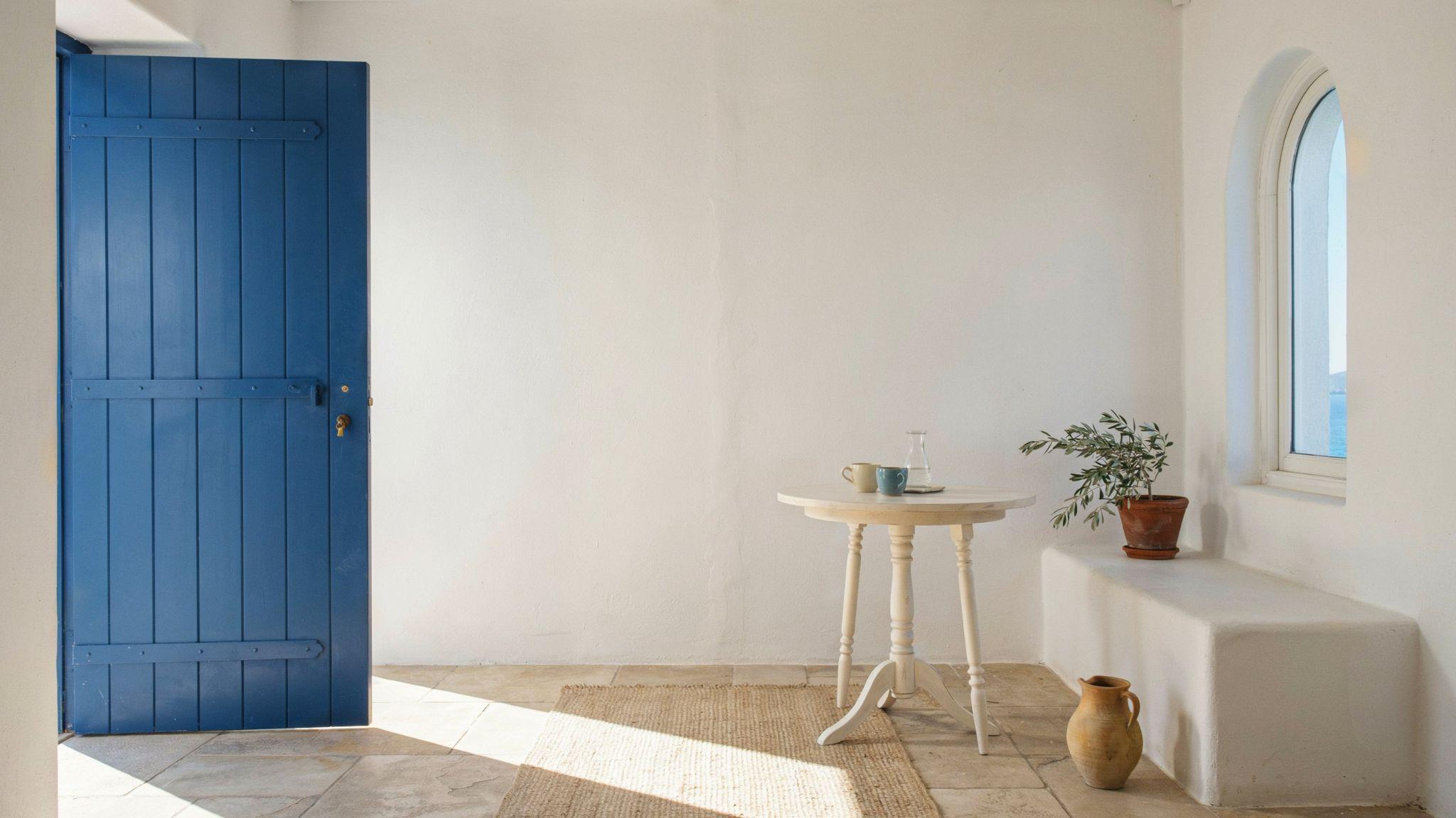 Greek Mediterranean interior with white walls, blue accents, and bright airy coastal design.