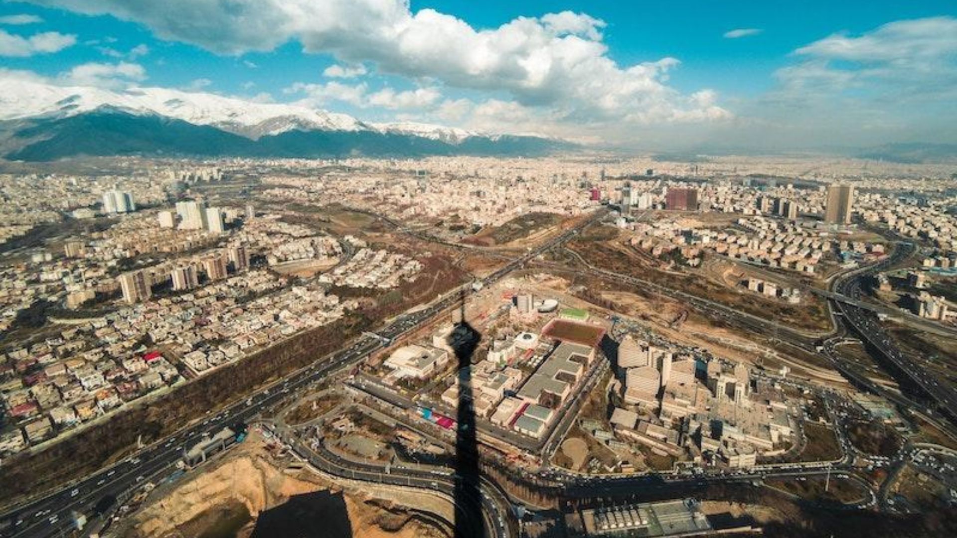 Aerial view of Tehran, Iran, showcasing the city's skyline and surrounding mountains.