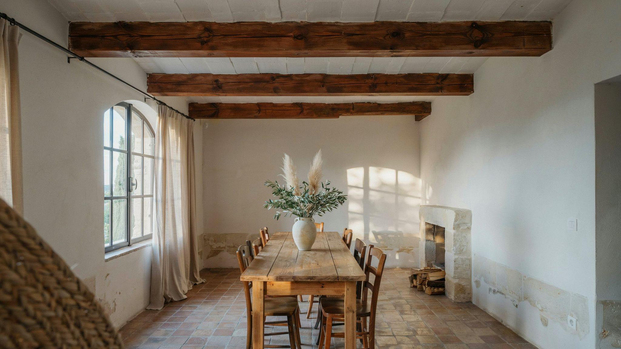 Mediterranean room with exposed wooden beams and warm natural lighting.