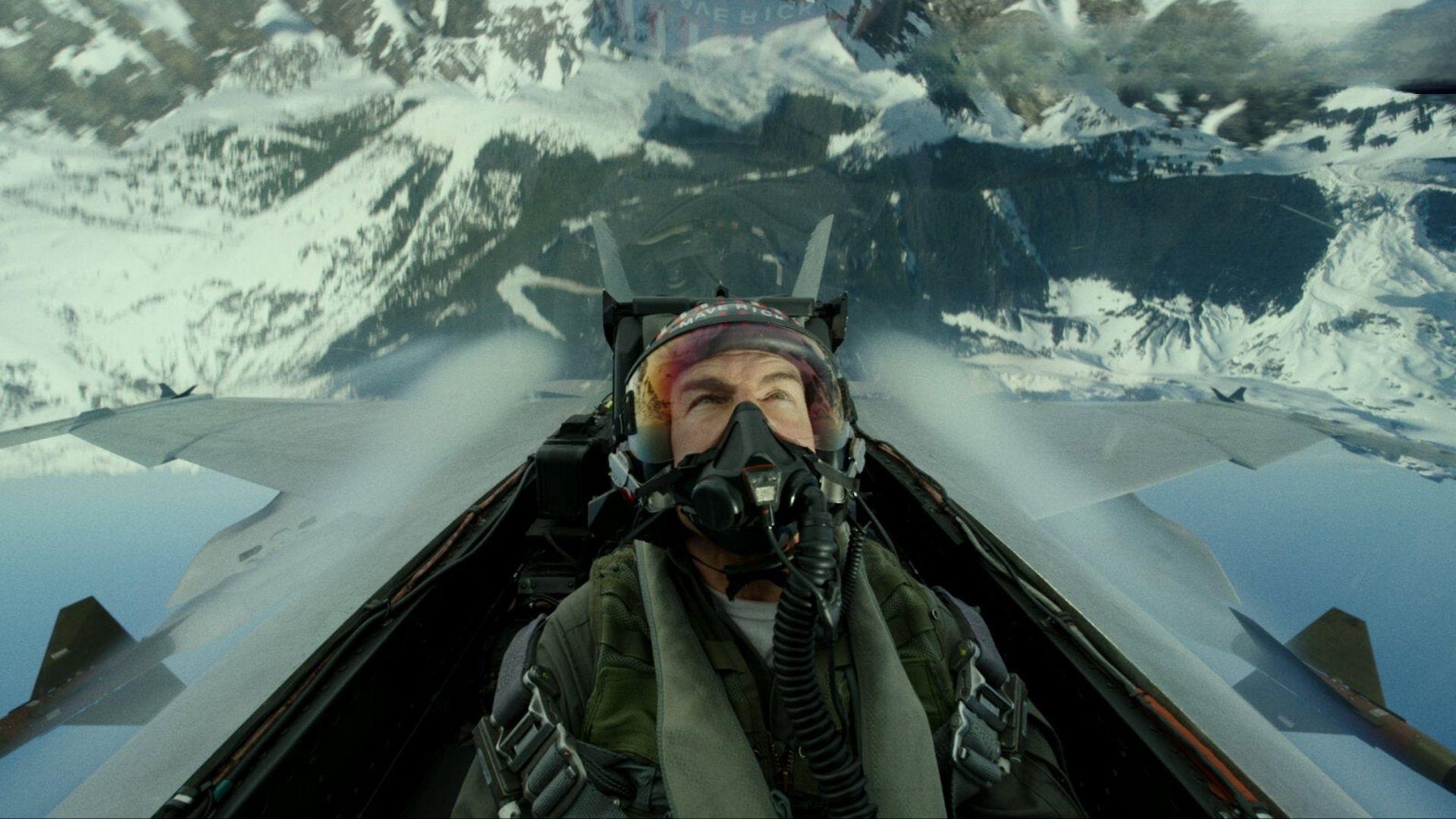 Top Gun: Maverick. Maverick in flight suit and oxygen mask pilots a jet over snowy mountains.