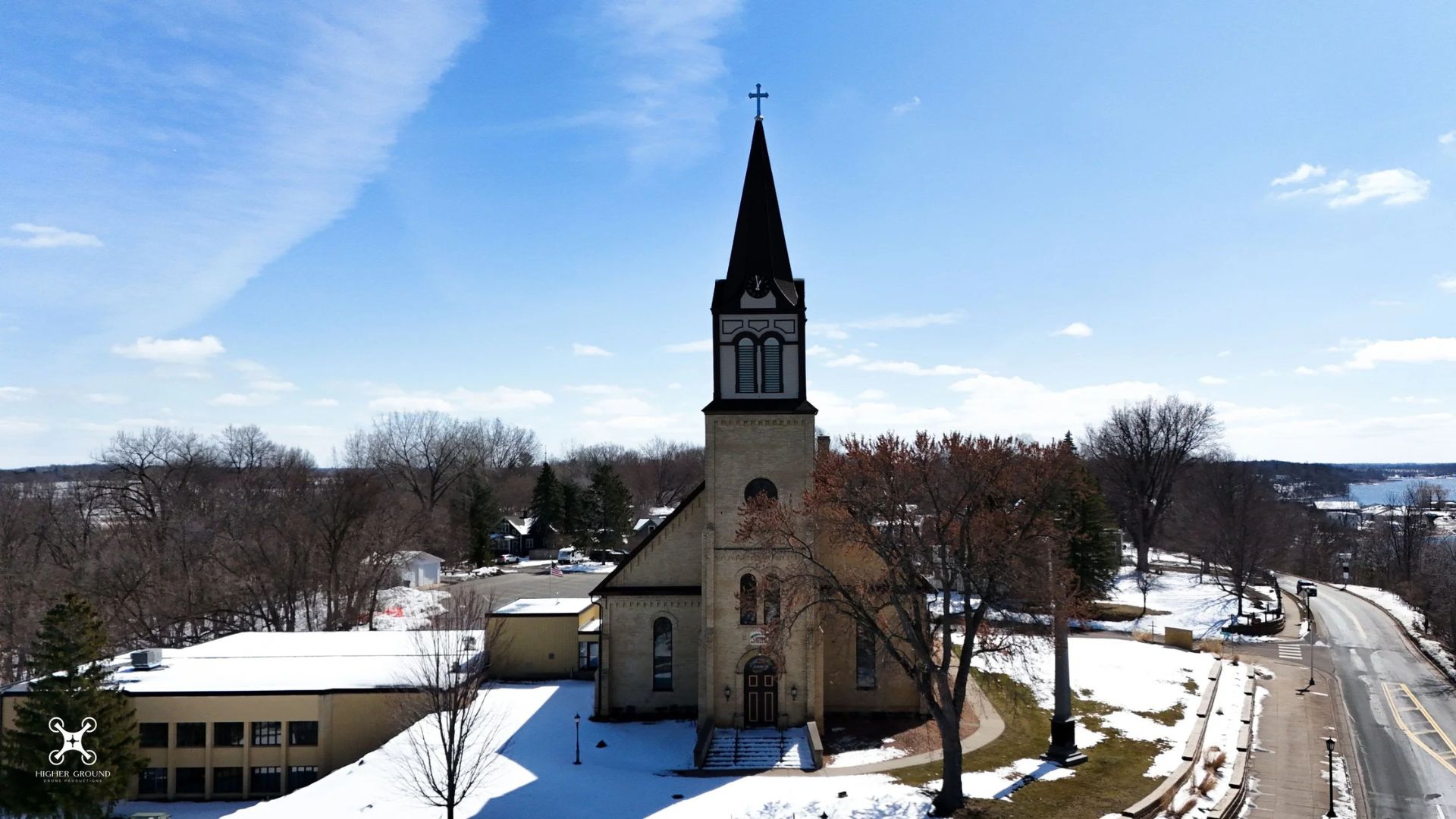  Historic Minnesota church landmark featured in the Grumpy Old Men series, surrounded by snowy grounds and small-town scenery under a clear blue sky.
