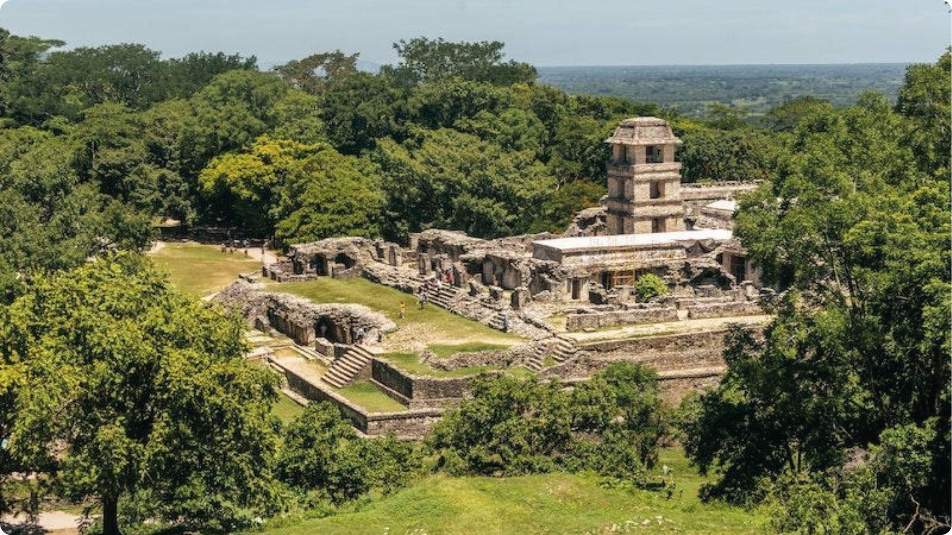 Aerial view of Palenque Palace stone tower rising above jungle canopy, Predator filming site.