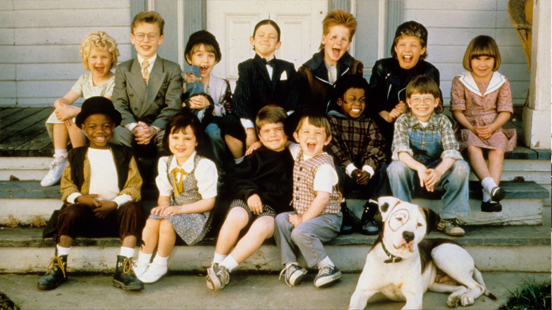 Full cast of the 1994 Little Rascals movie sitting on porch steps with dog Pete including Spanky Alfalfa Darla and Buckwheat